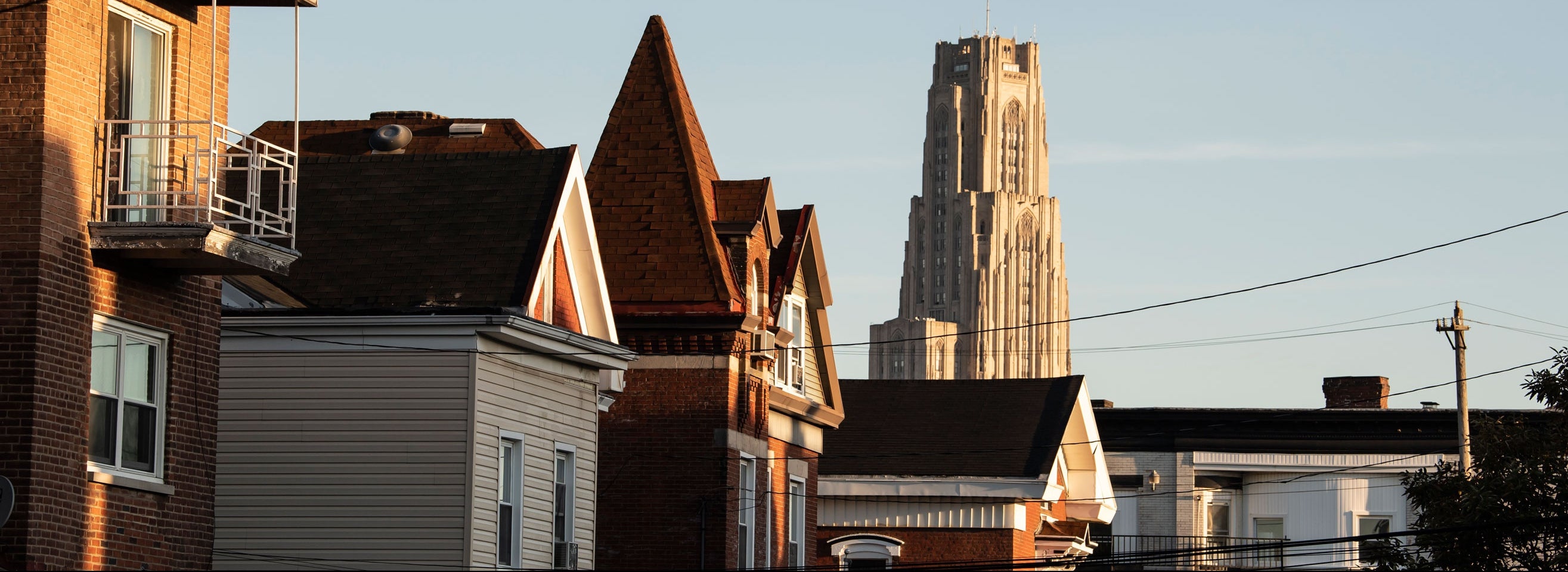 The rooftops of Oakland houses with the Cathedral of Learning in the background