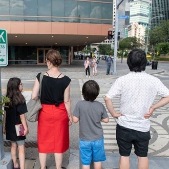 A family of four waits to cross a Downtown Pittsburgh intersection